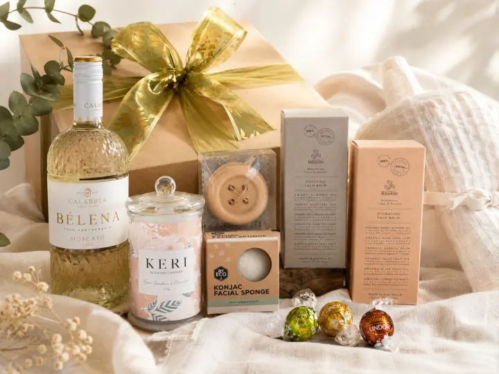Gift box with a gold ribbon, moscato and body care